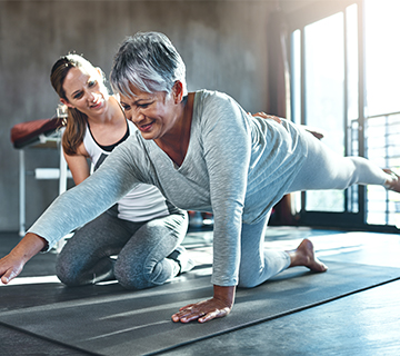 Woman stretching with trainer